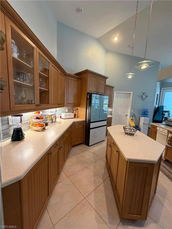 7791 Grande Pine Road Bokeelia, FL 33922 - Photo 42 of 45 a large kitchen with kitchen island a sink a stove a refrigerator and a dining table with wooden floor