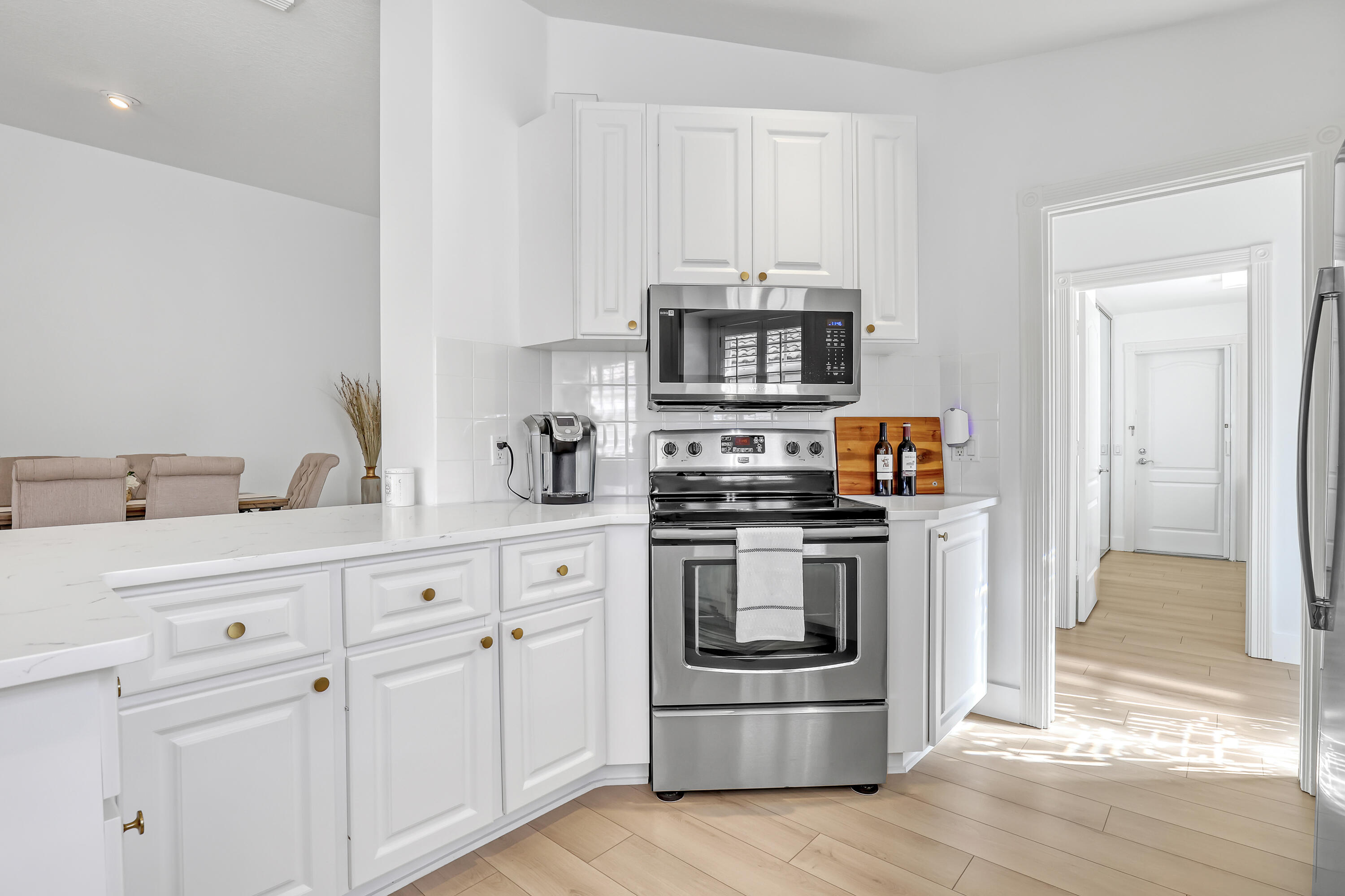 907 Southwest Balmoral Trace Stuart, FL 34997 - Photo 13 of 46 a kitchen with white cabinets stainless steel appliances and sink