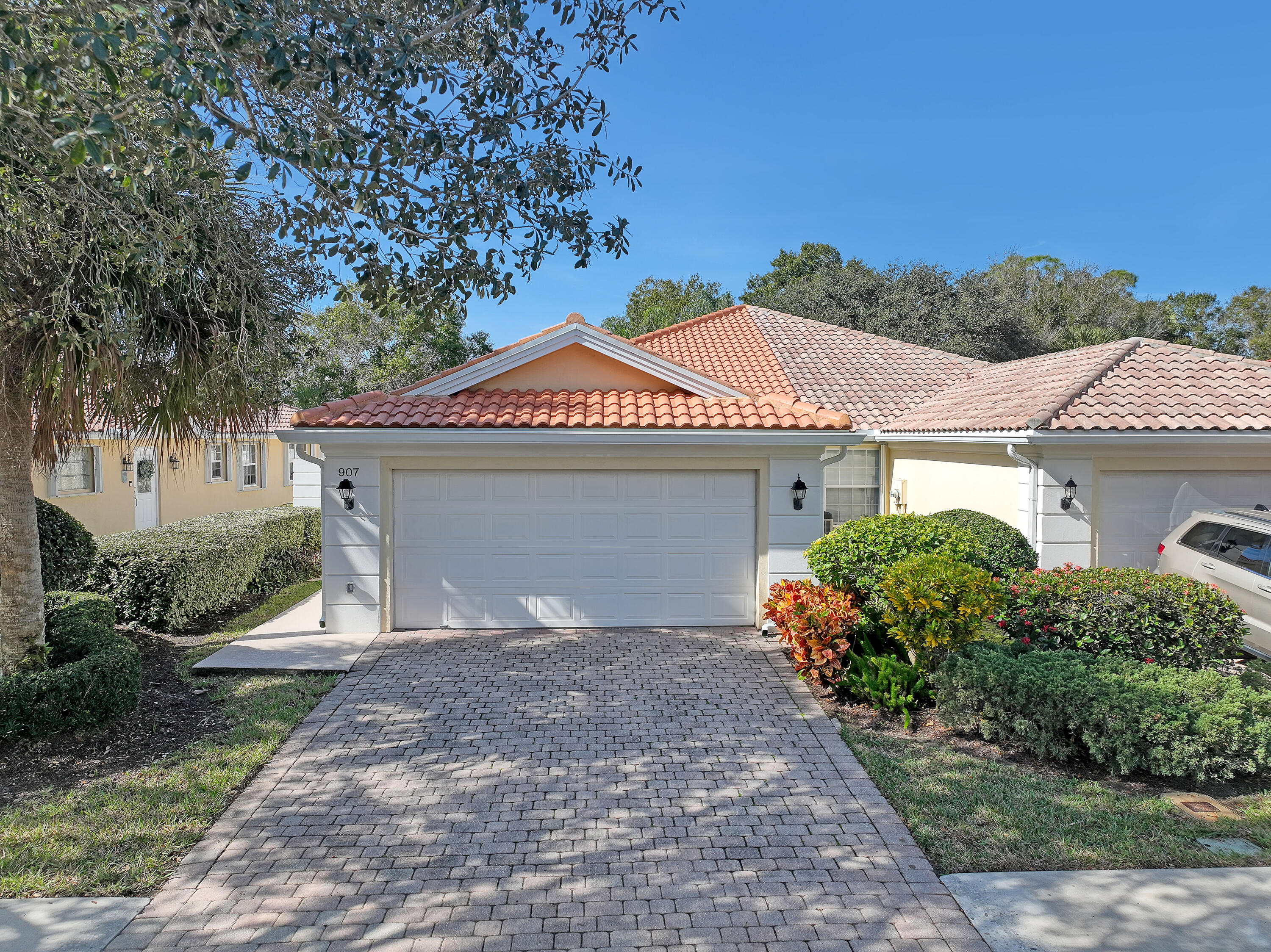 907 Southwest Balmoral Trace Stuart, FL 34997 - Photo 33 of 46 a front view of a house with a yard and garage