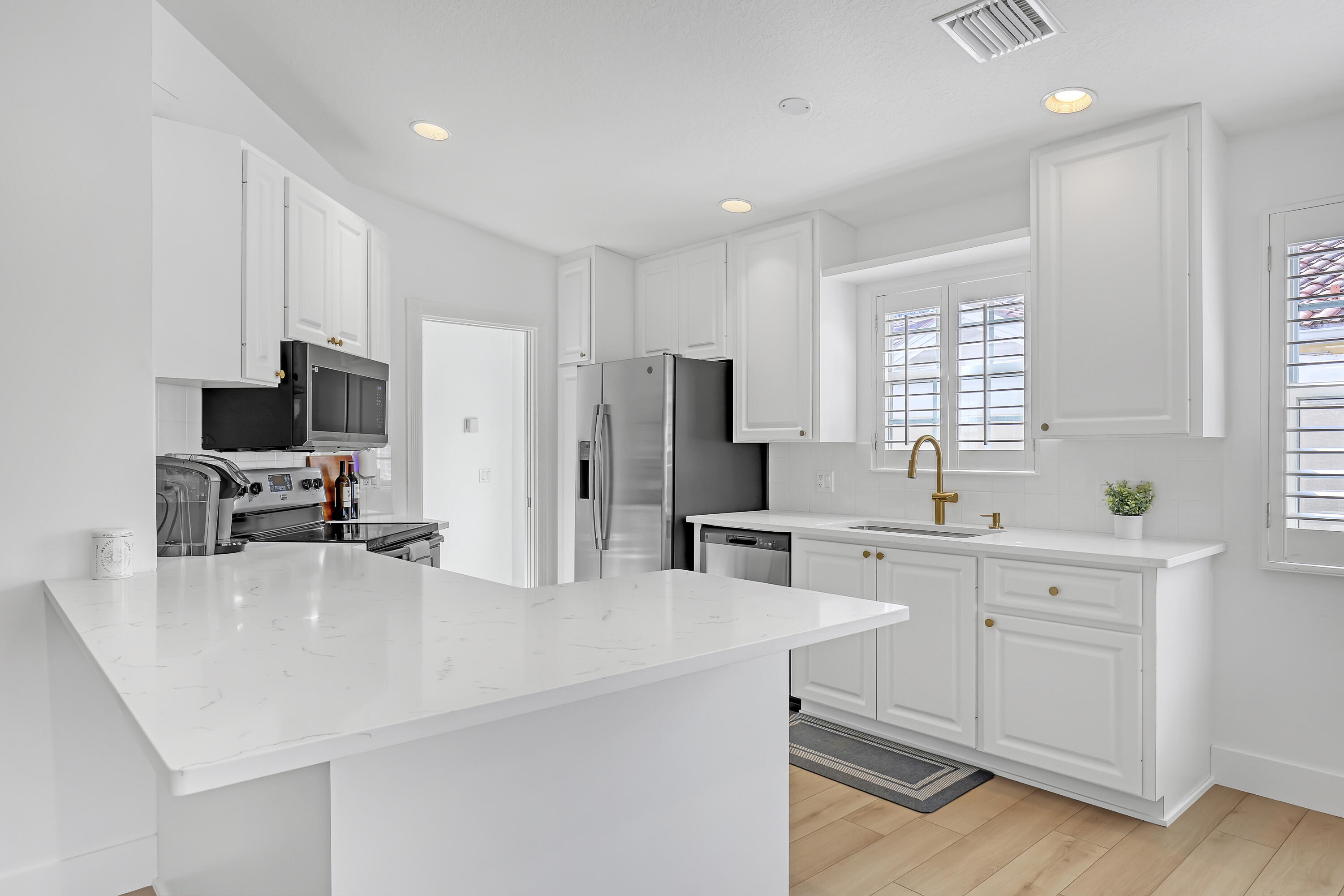 907 Southwest Balmoral Trace Stuart, FL 34997 - Photo 5 of 46 a kitchen with sink cabinets and refrigerator