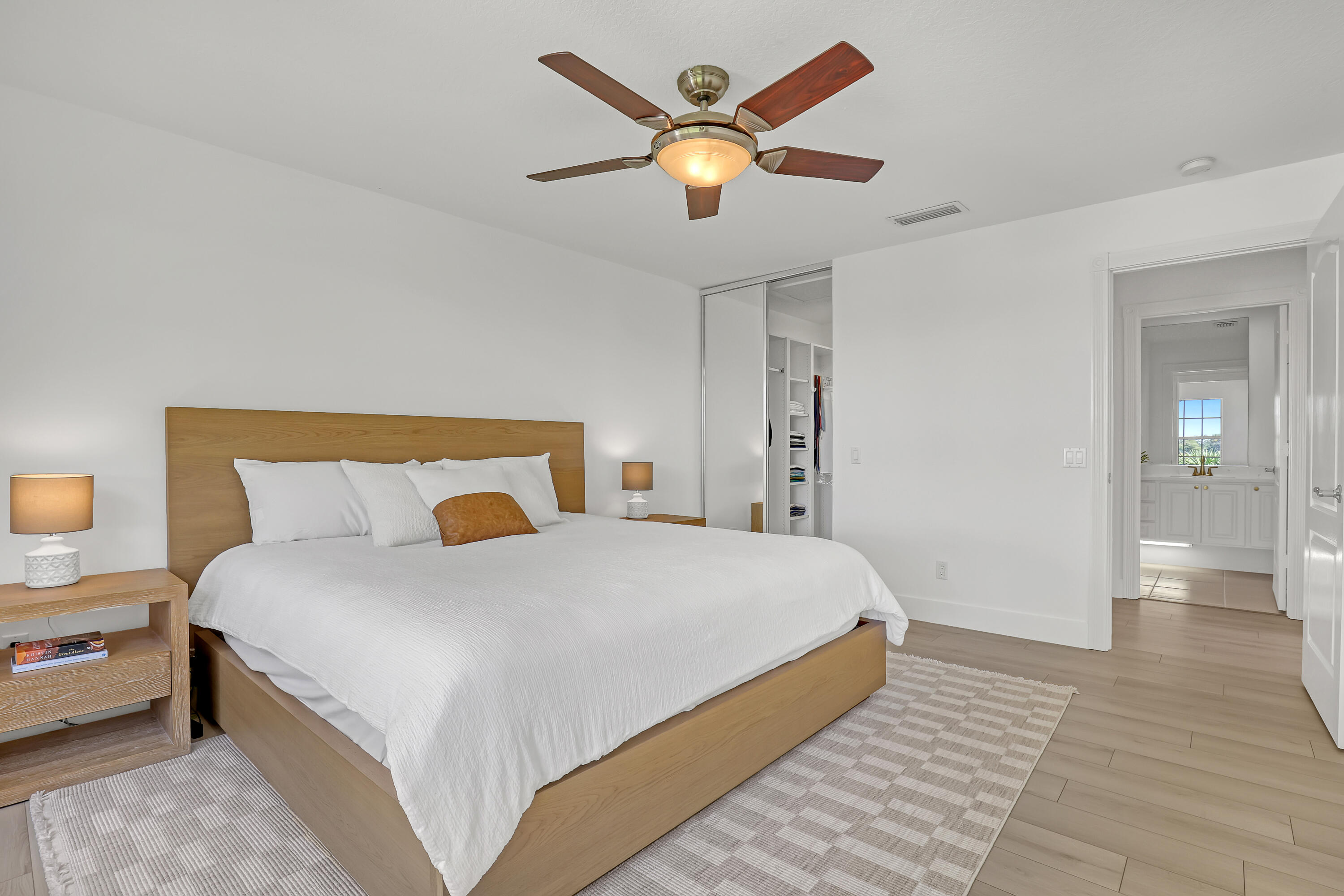 907 Southwest Balmoral Trace Stuart, FL 34997 - Photo 8 of 46 a bedroom with a large bed and a chandelier