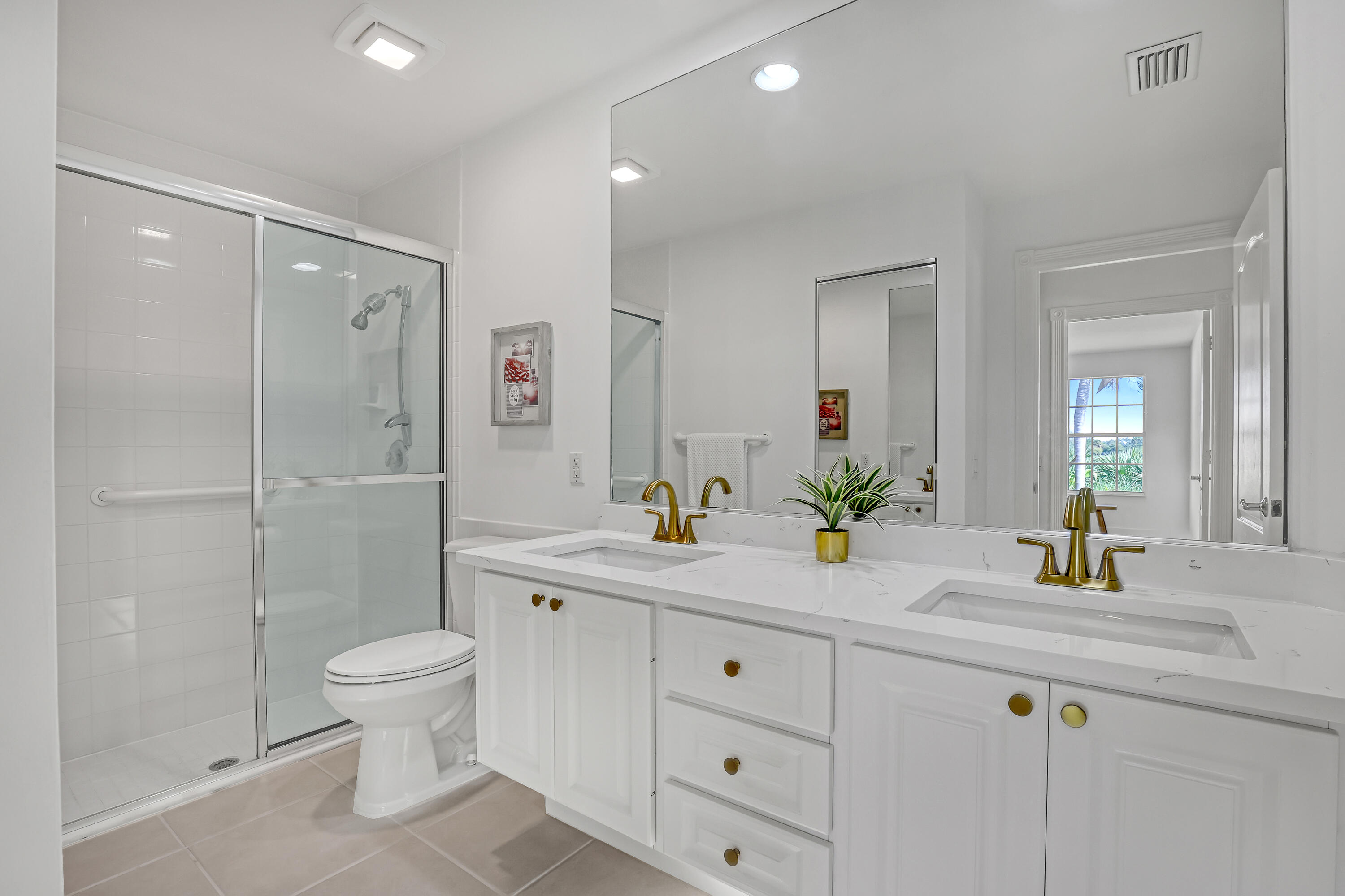 907 Southwest Balmoral Trace Stuart, FL 34997 - Photo 9 of 46 a bathroom with a double vanity sink toilet mirror and shower