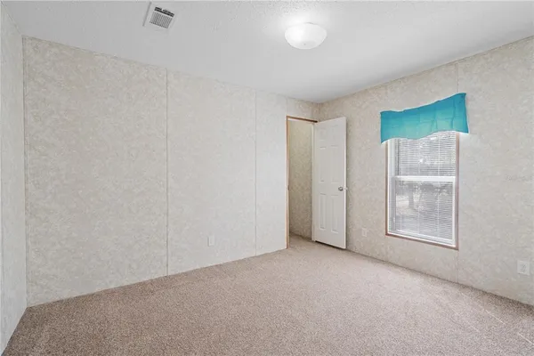 an empty room with windows and closet