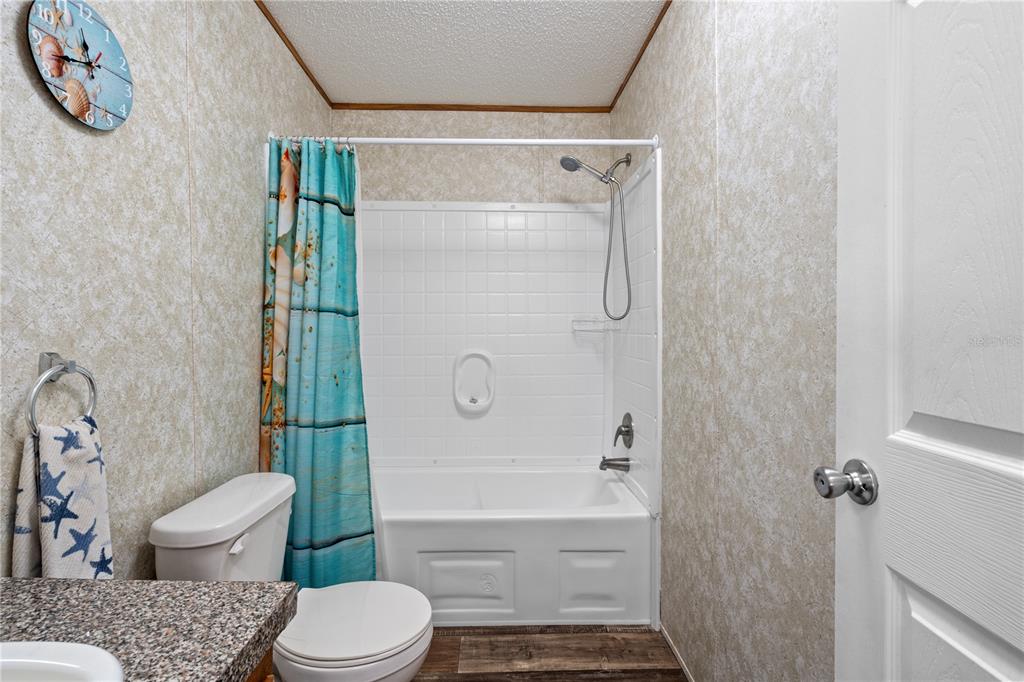 10811 Northeast 57th Street Bronson, FL 32621 - Photo 12 of 21 a bathroom with a granite countertop toilet and a shower