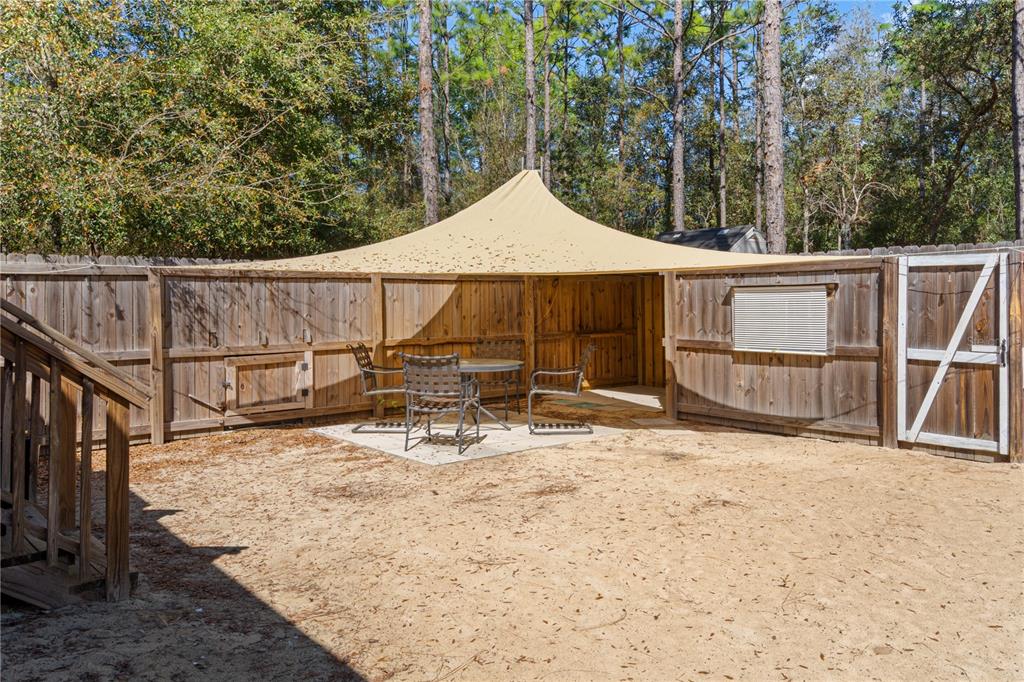 10811 Northeast 57th Street Bronson, FL 32621 - Photo 17 of 21 a view of roof deck with wooden fence and a couple of chairs