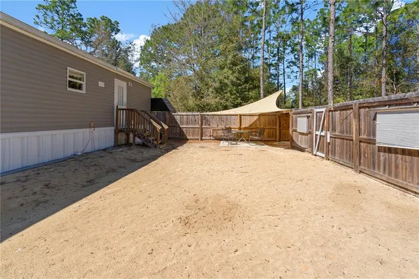 a view of backyard with small cabin and wooden fence