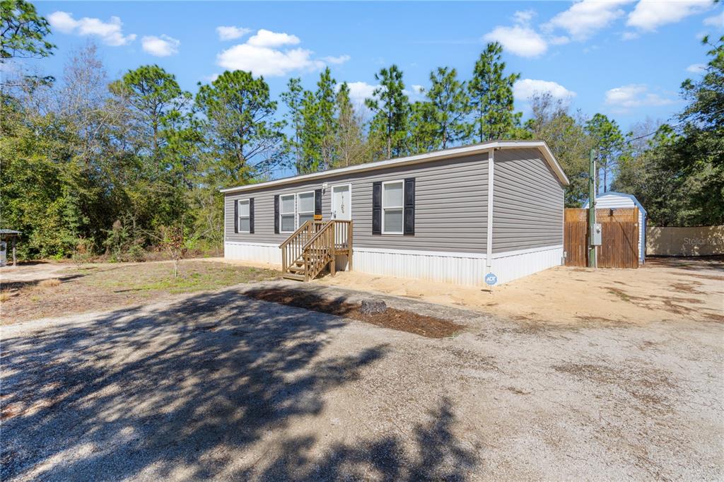 10811 Northeast 57th Street Bronson, FL 32621 - Photo 2 of 21 a house with trees in the background