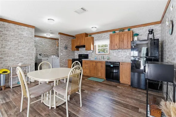 a kitchen with a table chairs a sink dishwasher refrigerator and cabinets