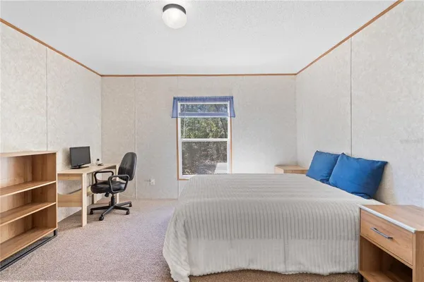 a bedroom with a bed and a chair in it