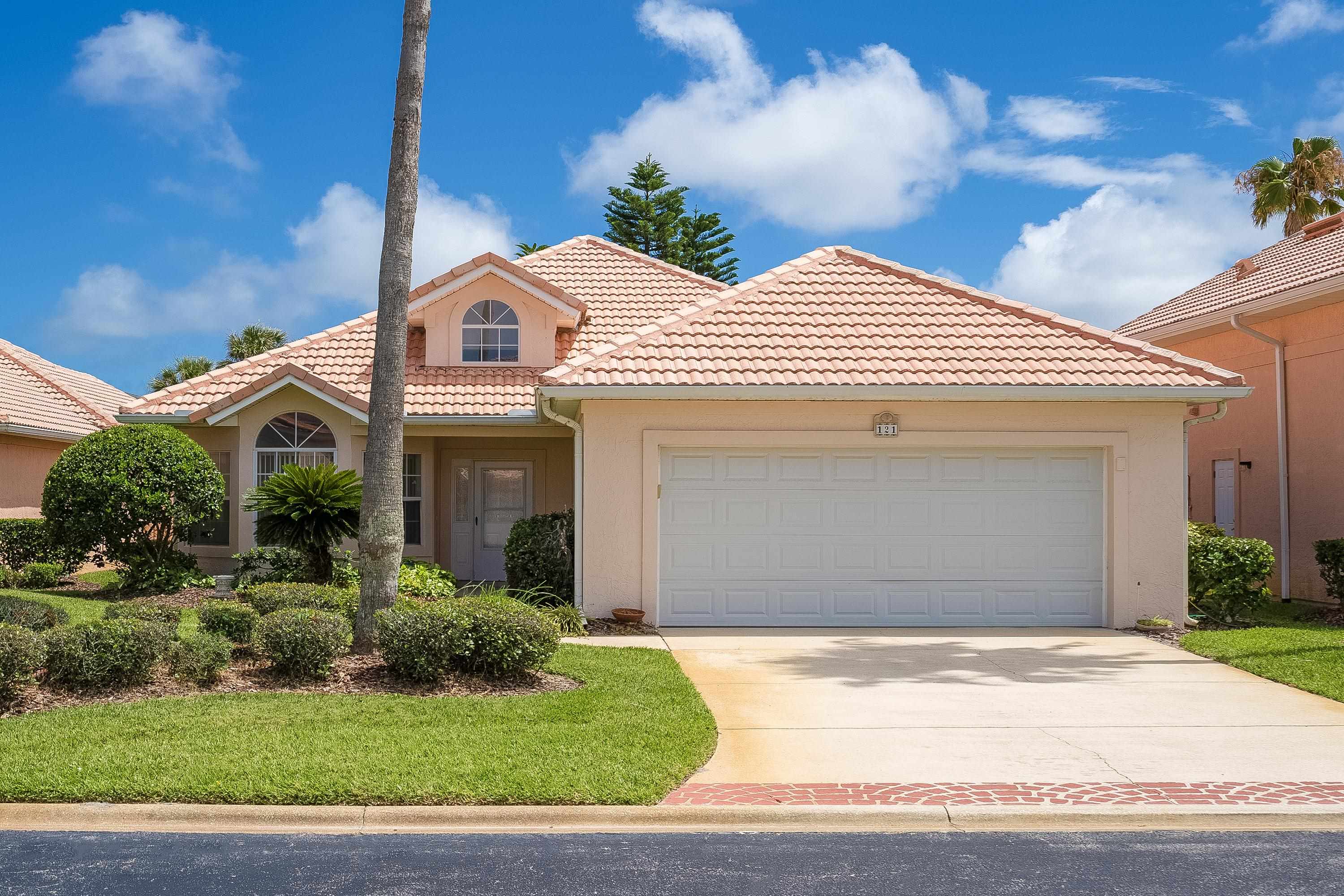 a view of a white house with a yard and large tree