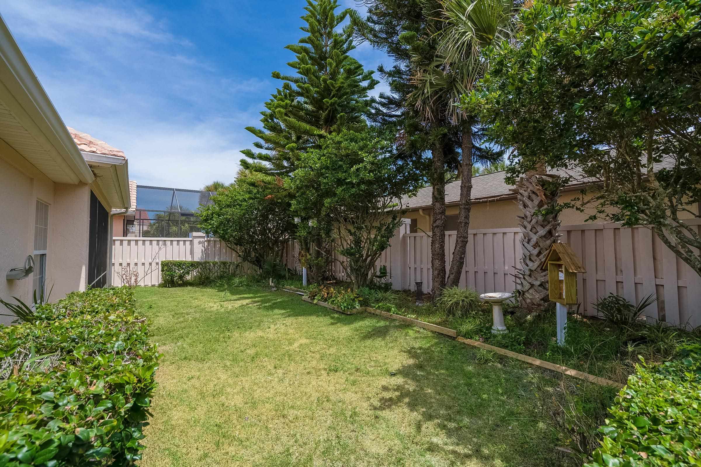 121 Tide Watch Drive St. Augustine, FL 32080 - Photo 16 of 49 a view of a backyard with plants and large trees