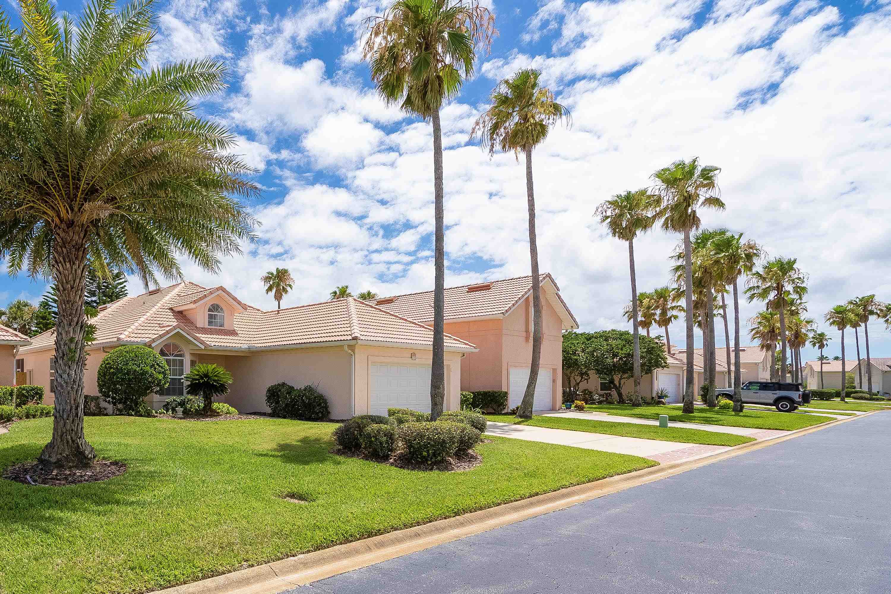 121 Tide Watch Drive St. Augustine, FL 32080 - Photo 2 of 49 a view of a white house with a big yard and palm trees