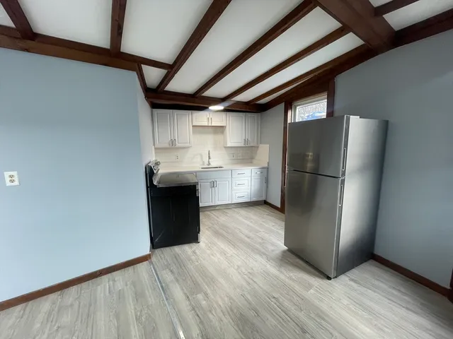 a kitchen with granite countertop a refrigerator and a stove top oven