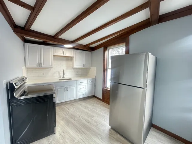 a kitchen with a refrigerator sink and cabinets