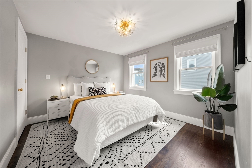 3 Glover Court, Unit 2 Boston, MA 02127 - Photo 17 of 27 a bed room with a bed and a chandelier