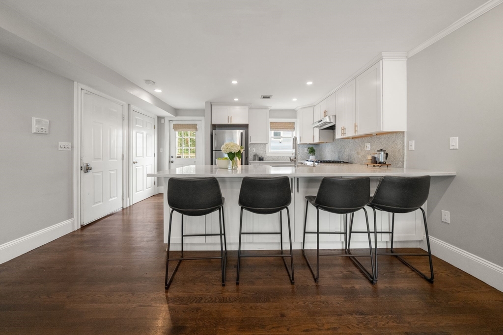 3 Glover Court, Unit 2 Boston, MA 02127 - Photo 2 of 27 a kitchen with stainless steel appliances kitchen island granite countertop a dining table chairs and granite counter tops