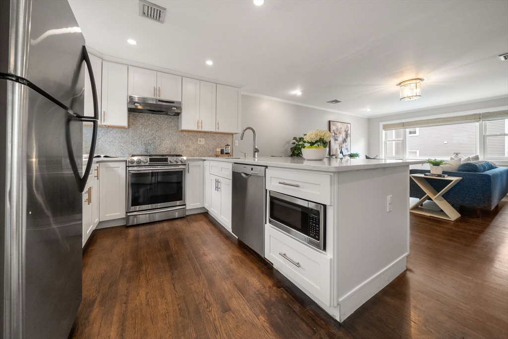 3 Glover Court, Unit 2 Boston, MA 02127 - Photo 4 of 27 a kitchen with stainless steel appliances a stove a sink and a refrigerator