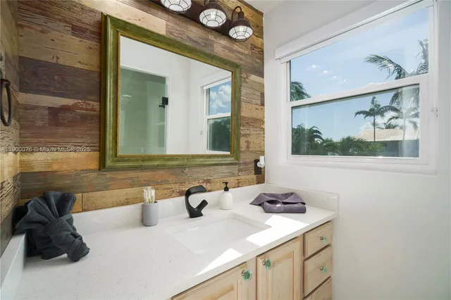a bathroom with a sink and mirror with toilet