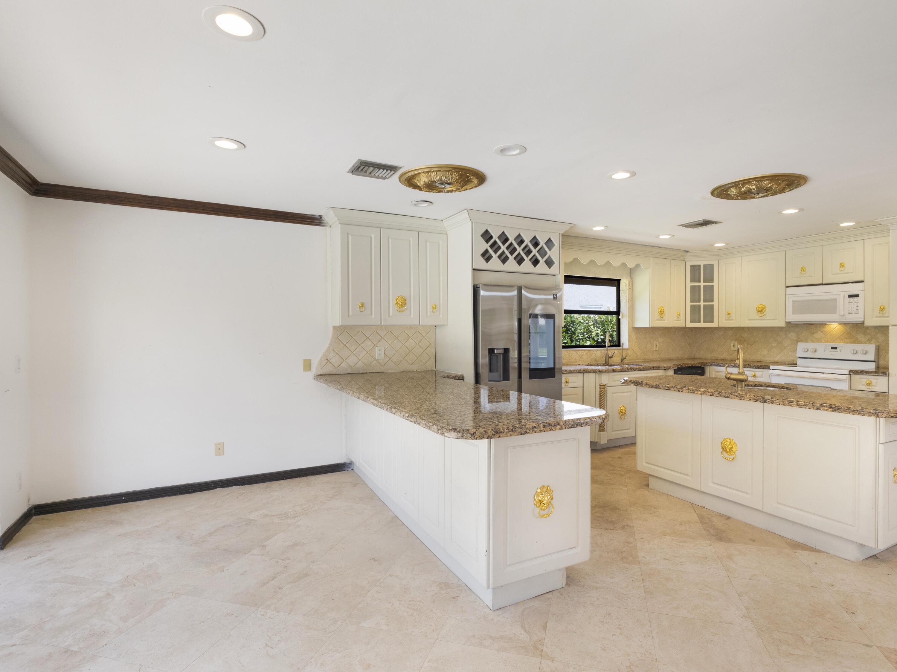 21130 White Oak Avenue Boca Raton, FL 33428 - Photo 12 of 38 a kitchen with stainless steel appliances granite countertop a sink and a refrigerator