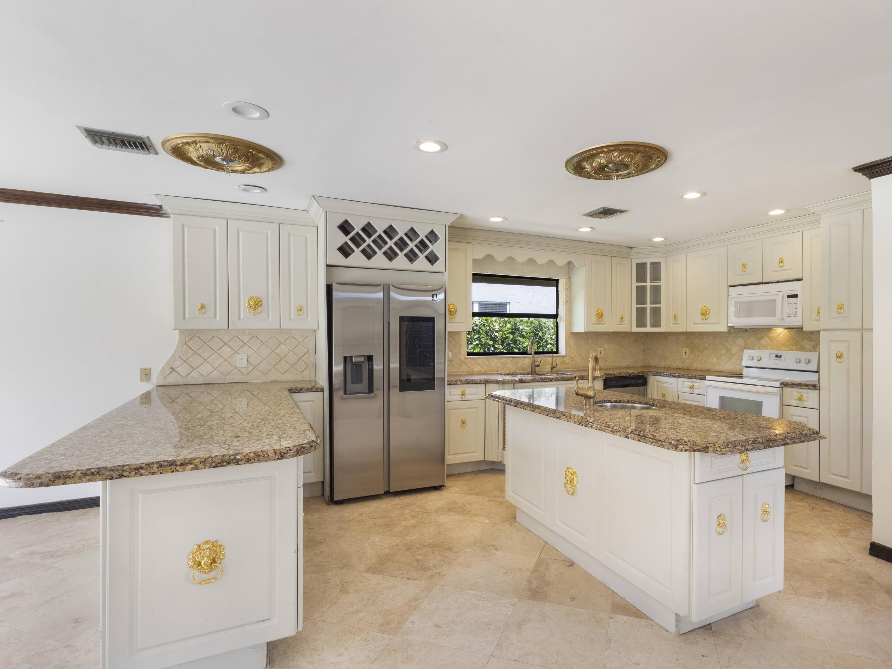 21130 White Oak Avenue Boca Raton, FL 33428 - Photo 13 of 38 a kitchen with a stove a refrigerator and a stove top oven