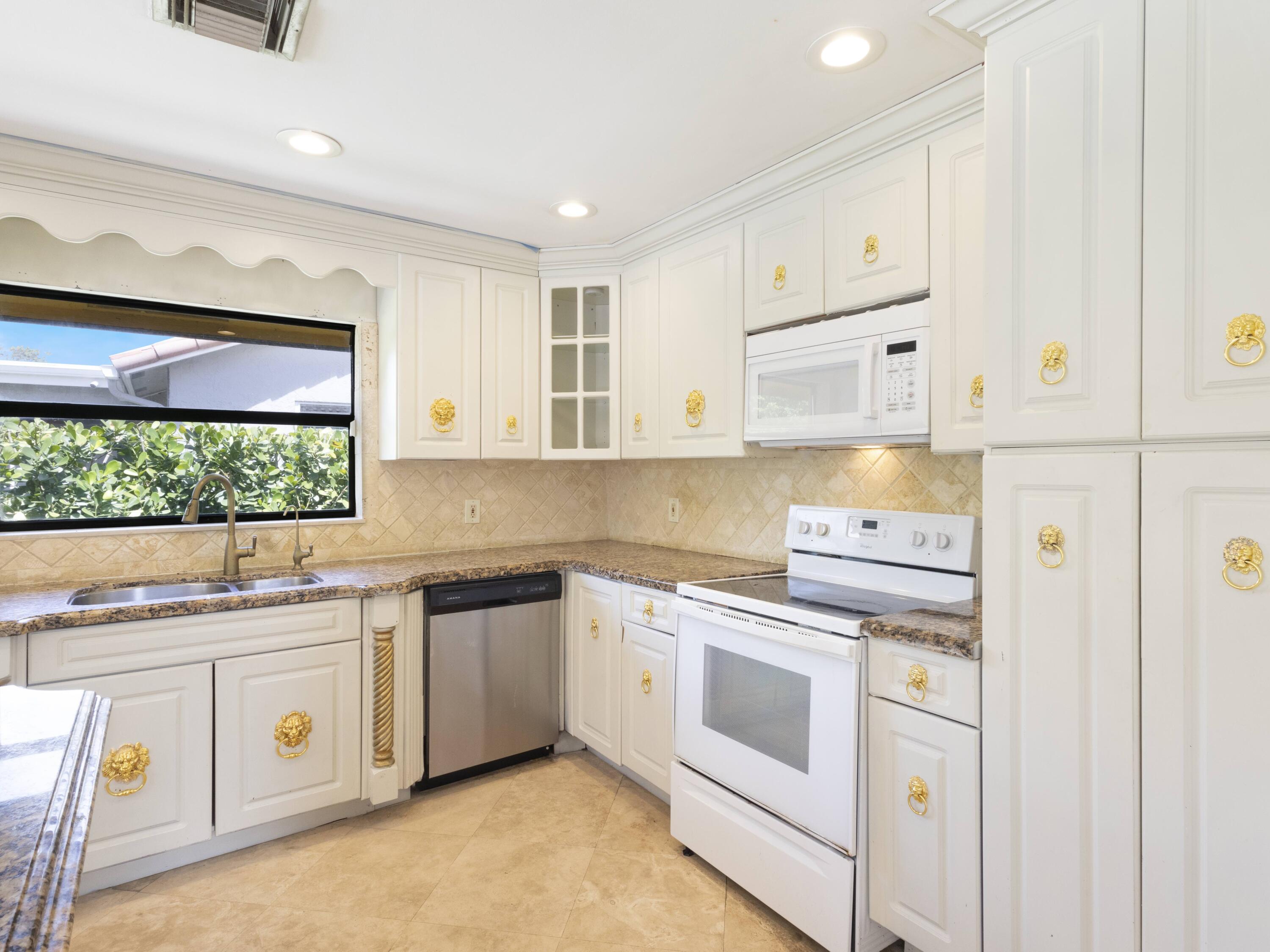 21130 White Oak Avenue Boca Raton, FL 33428 - Photo 14 of 38 a kitchen with white cabinets and white appliances