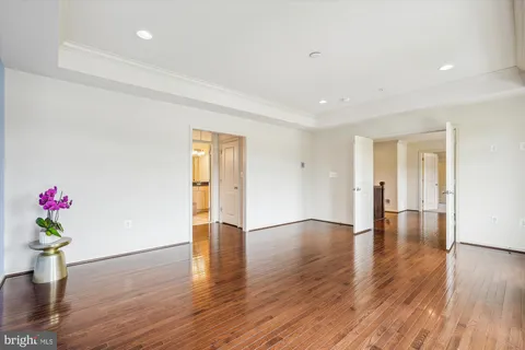 a view of an empty room with wooden floor and closet