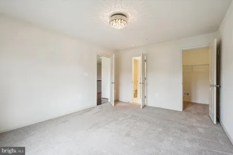 a view of an empty room with wooden floor and closet