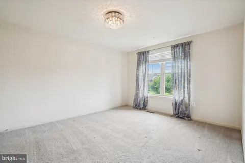 a view of an empty room with wooden floor and stairs
