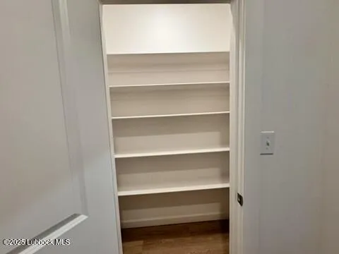 an empty room with wooden floor and ceiling fan