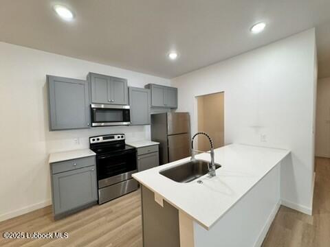 5719 Kemper Street, Unit A Lubbock, TX 79416 - Photo 6 of 21 a kitchen with stainless steel appliances a sink dishwasher a refrigerator a microwave oven with cabinets and wooden floor