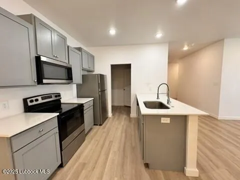a kitchen with sink a refrigerator and wooden floor
