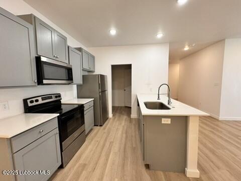 5719 Kemper Street, Unit A Lubbock, TX 79416 - Photo 7 of 21 a kitchen with stainless steel appliances a sink dishwasher a stove top oven a refrigerator with grey cabinets and wooden floor
