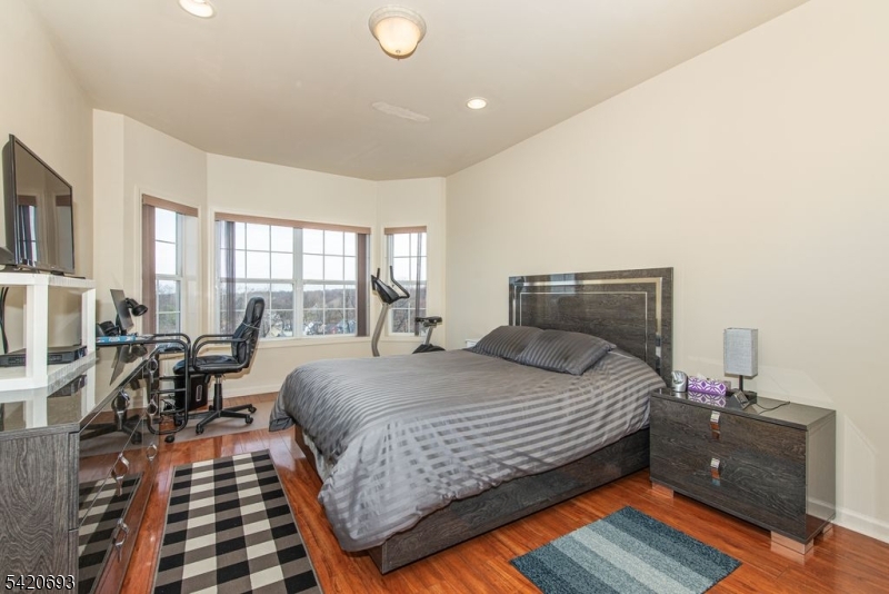 375 Rifle Camp Road, Unit 403 Woodland Park, NJ 07424 - Photo 15 of 24 a bedroom with a bed and wooden floor