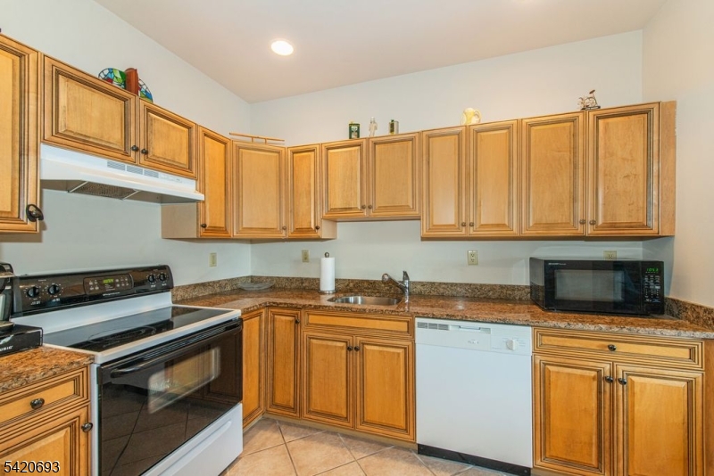 375 Rifle Camp Road, Unit 403 Woodland Park, NJ 07424 - Photo 20 of 24 a kitchen with stainless steel appliances granite countertop a sink stove and cabinets