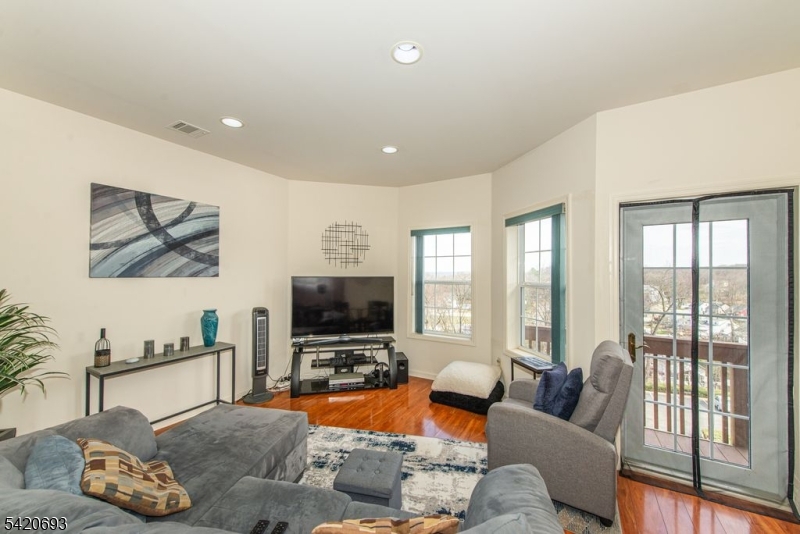 375 Rifle Camp Road, Unit 403 Woodland Park, NJ 07424 - Photo 22 of 24 a living room with furniture and a flat screen tv
