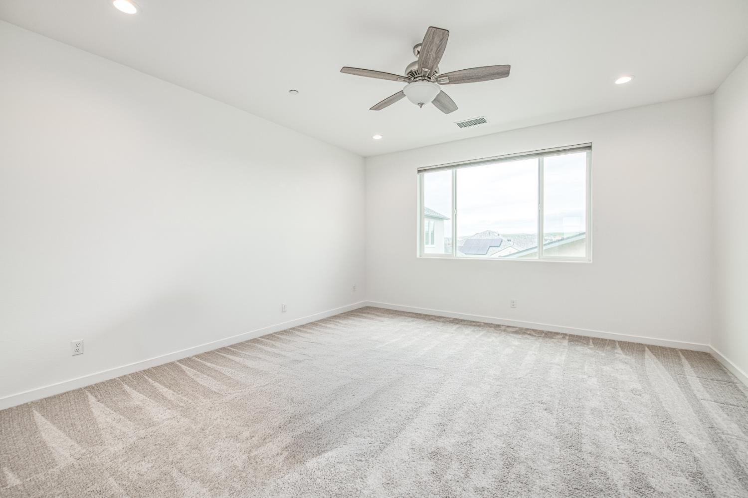 849 Livio Way Madera, CA 93636 - Photo 12 of 74 an empty room with a window and a fan