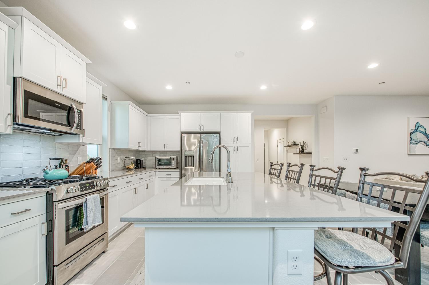 849 Livio Way Madera, CA 93636 - Photo 20 of 74 a kitchen with stainless steel appliances granite countertop a stove a sink a microwave a dining table and chairs