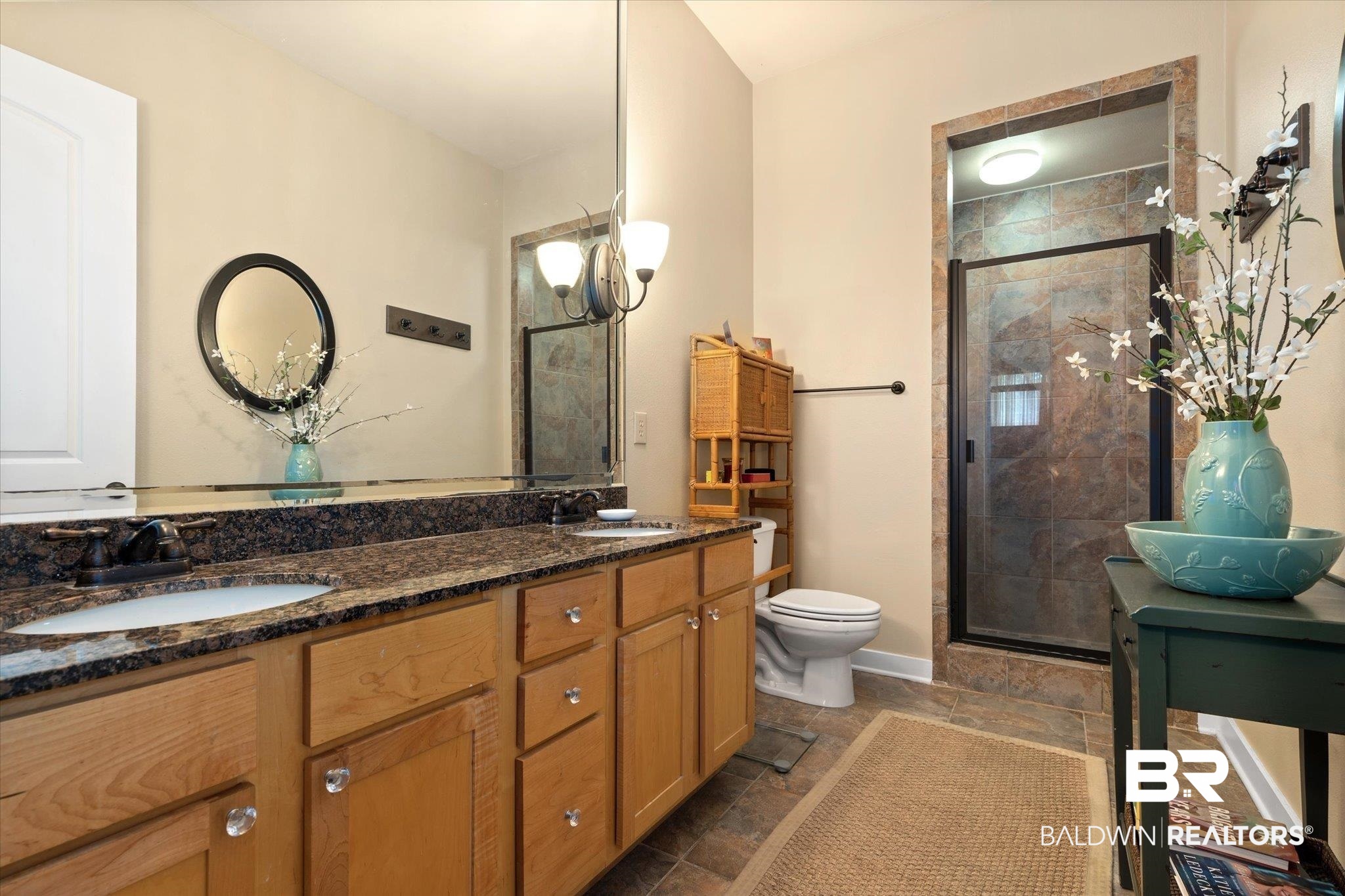 1430 Regency Road, Unit C103 Gulf Shores, AL 36542 - Photo 11 of 29 Bathroom featuring double vanity, a shower stall, and stone tile flooring