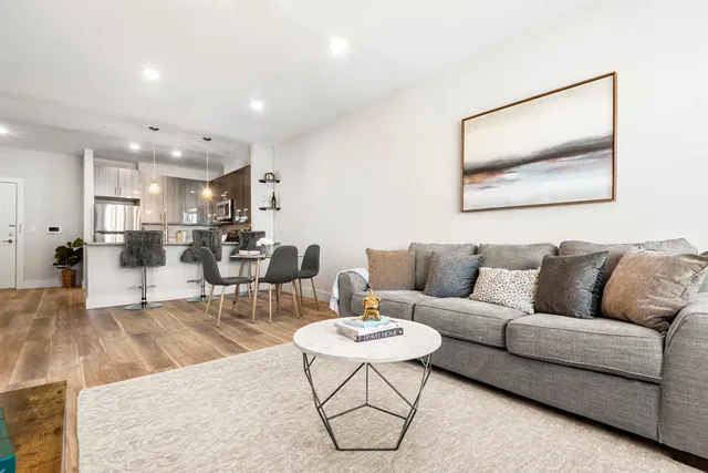 a living room with furniture and kitchen view