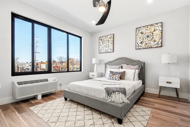 a bedroom with a bed and a large window