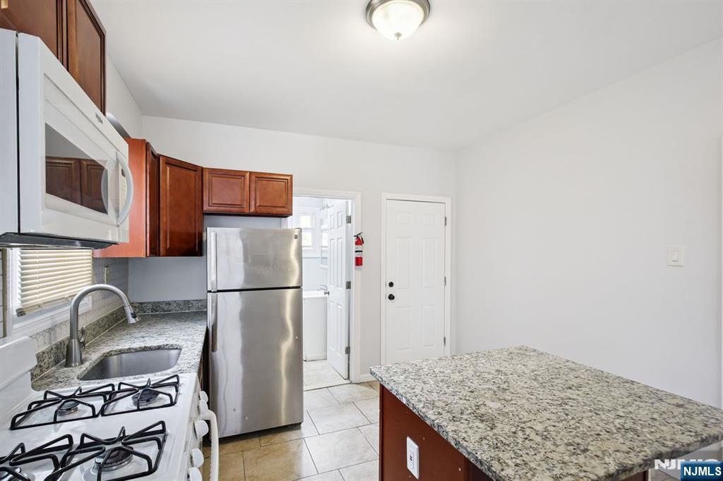 750 South 17th Street Newark, NJ 07103 - Photo 11 of 25 a kitchen with stainless steel appliances granite countertop a refrigerator sink and stove