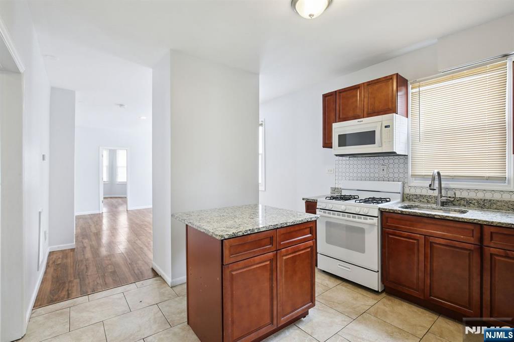 750 South 17th Street Newark, NJ 07103 - Photo 12 of 25 a kitchen with stainless steel appliances granite countertop a stove a sink and a microwave