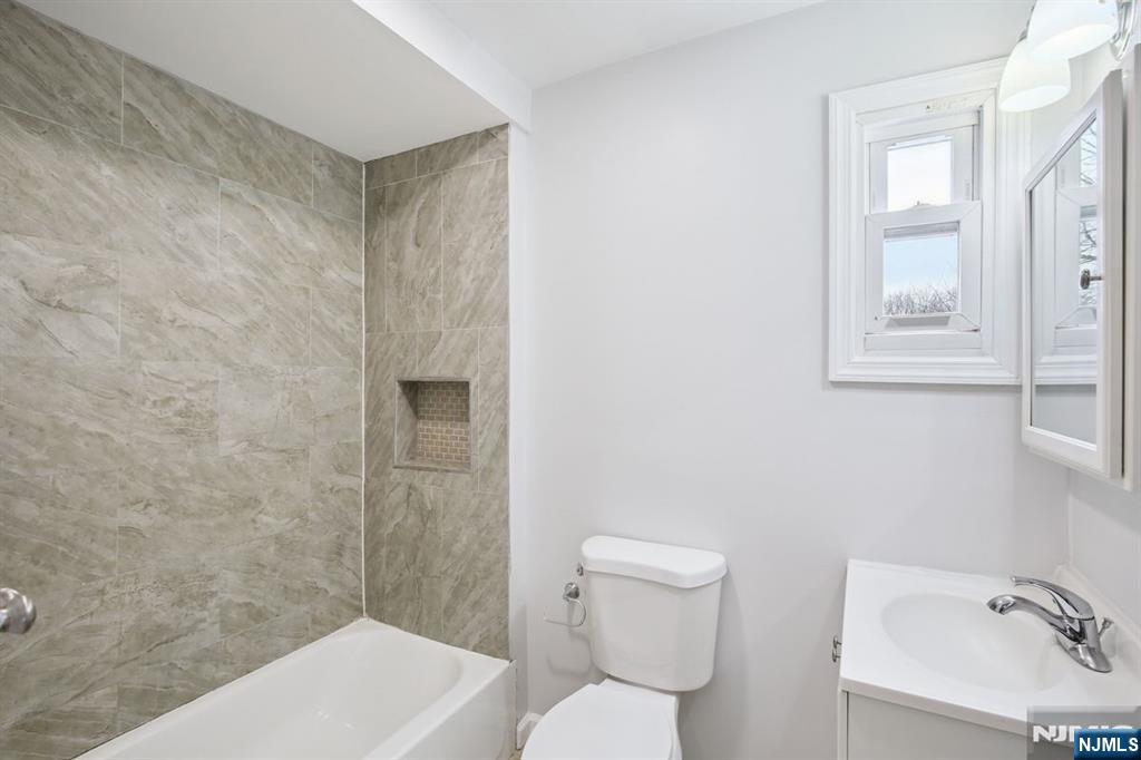 750 South 17th Street Newark, NJ 07103 - Photo 14 of 25 a bathroom with a toilet a sink a mirror and vanity