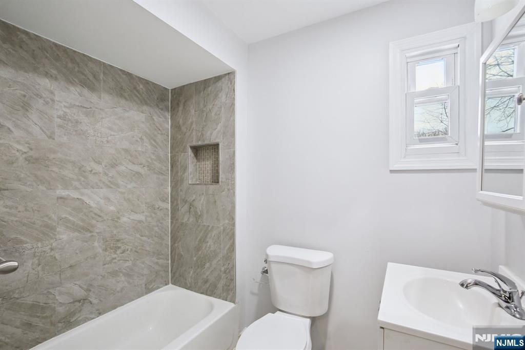 750 South 17th Street Newark, NJ 07103 - Photo 21 of 25 a bathroom with a toilet a sink a mirror and bathtub