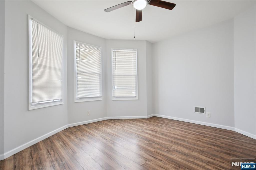 750 South 17th Street Newark, NJ 07103 - Photo 6 of 25 an empty room with wooden floor fan and windows