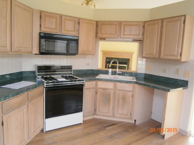 N686 Chelsea Circle Winfield, IL 60190 - Photo 6 of 25 a kitchen with granite countertop a stove top oven microwave and cabinets