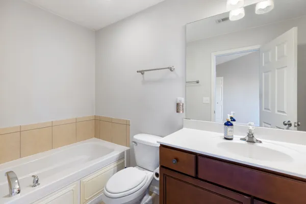 a bathroom with a sink a toilet a mirror and shower