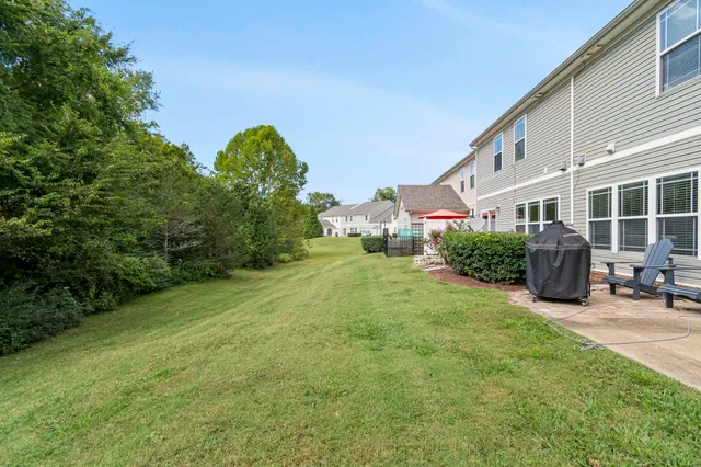 a view of a house with backyard and sitting area