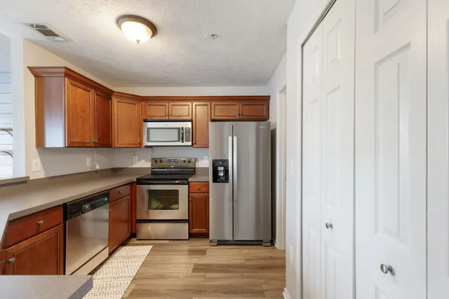 a kitchen with stainless steel appliances granite countertop a refrigerator and a sink