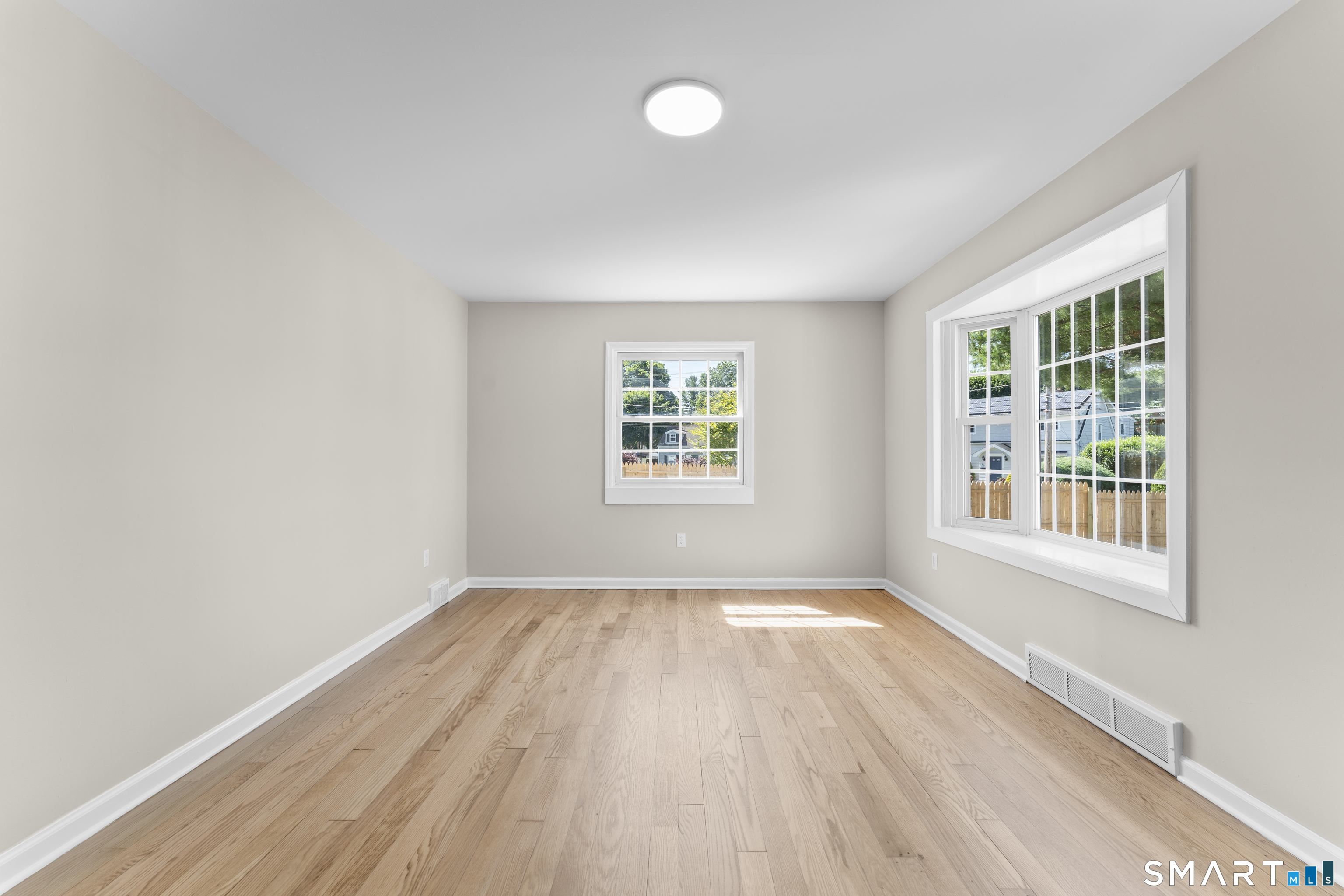 110 Minturn Road Bridgeport, CT 06606 - Photo 4 of 29 an empty room with wooden floor and windows